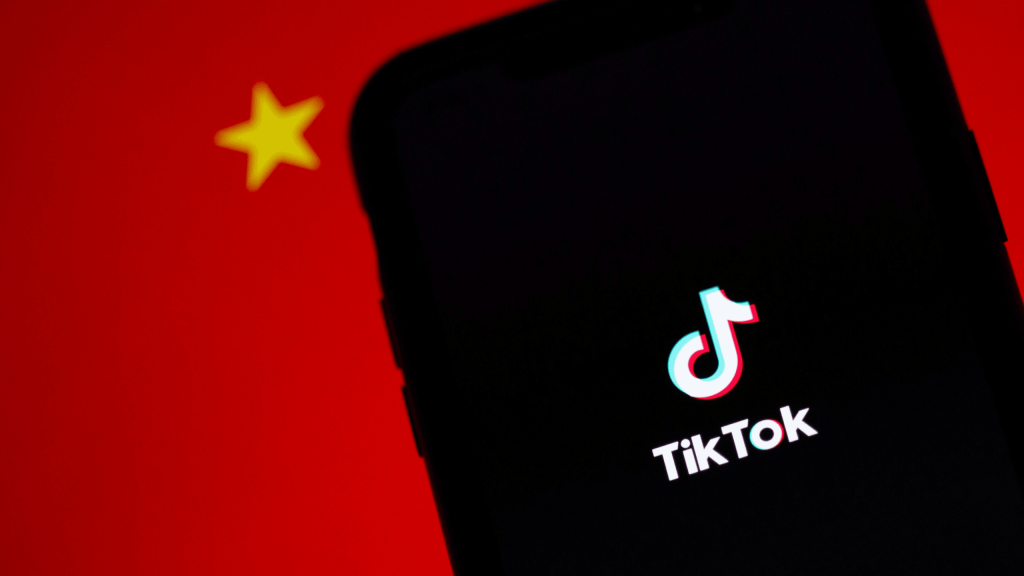 TikTok logo on phone screen against Chinese flag