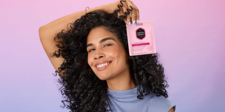 woman with curly hair posing with hair mask