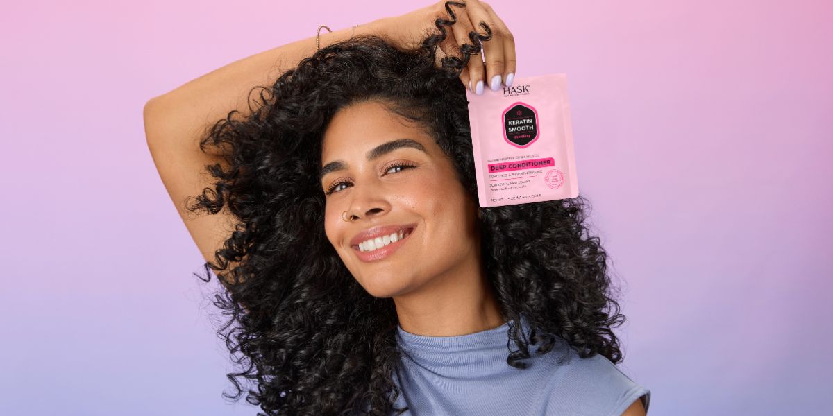 woman with curly hair posing with hair mask