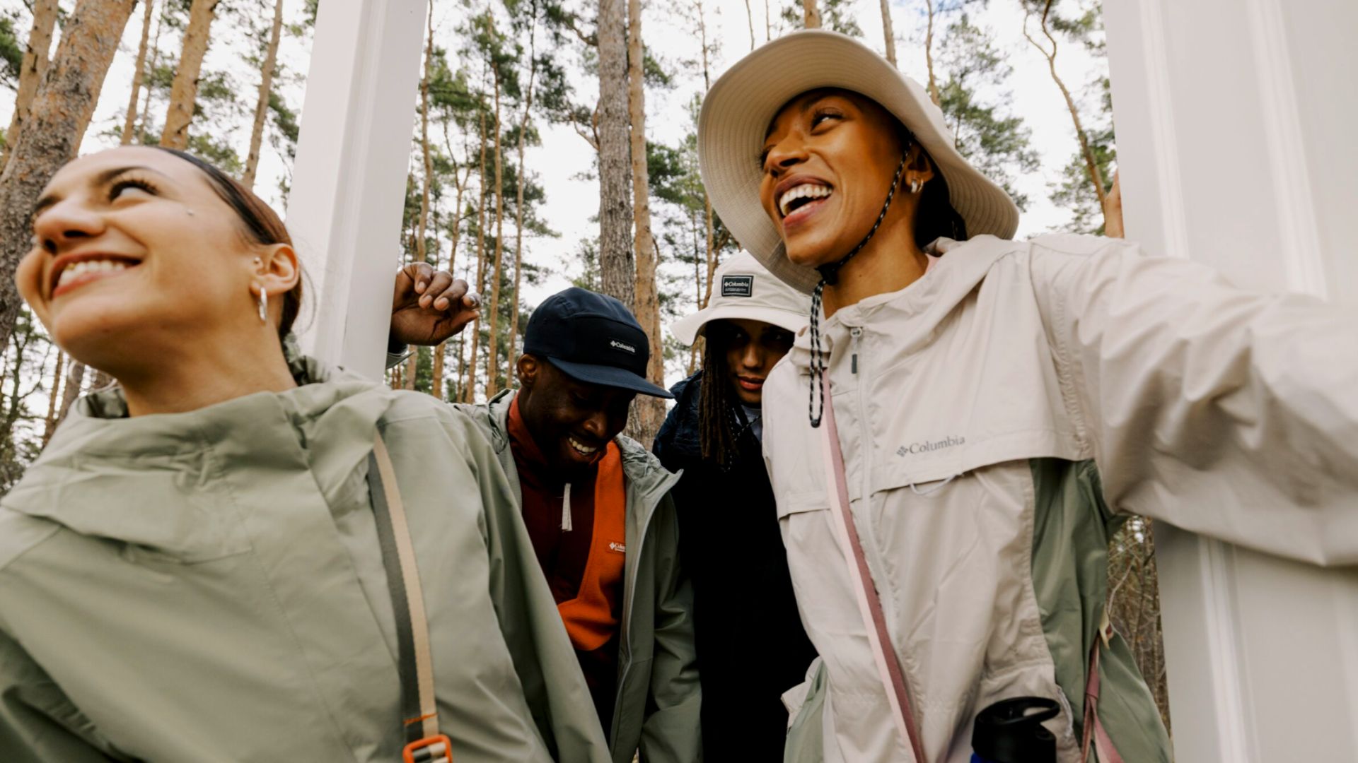 a group of young people smiling as they enter a door in a forest wearing ecommerce store zalando clothing