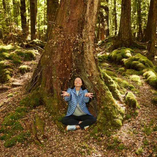 woman-smiling-sitting-by-tree woman smiling sitting by tree
